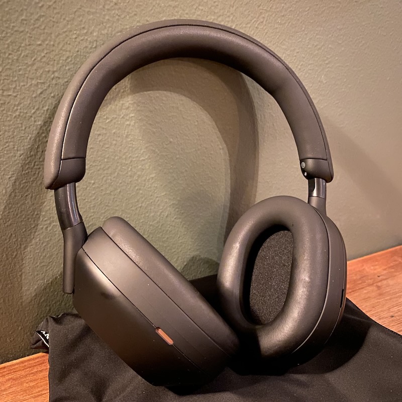 A pair of Sony WH-1000MX5 leaning on a green wall