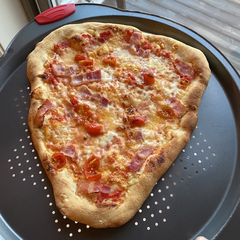 Photo of a home baked pizza with cheese and bacon