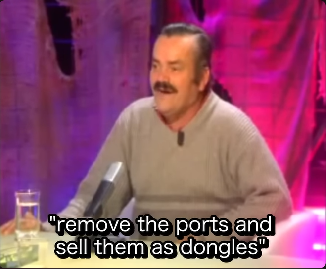 Screenshot of YouTube video meme featuring "Spanish Laughing Guy" with fake subtitles about how Apple came up with the idea of removing ports and instead selling dongles as a way to generate more profit.